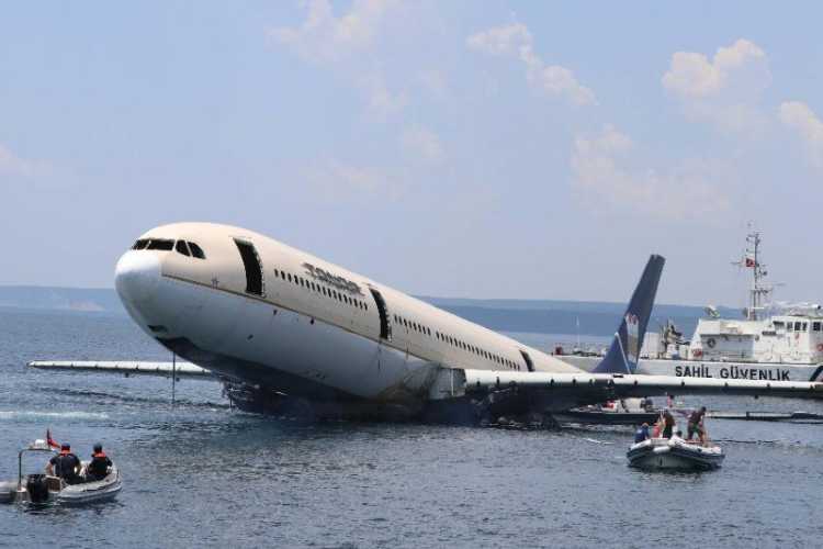 Airbus A330 aircraft being sunk off İbrice Harbor in Saros Gulf as boats and spectators gather around the site