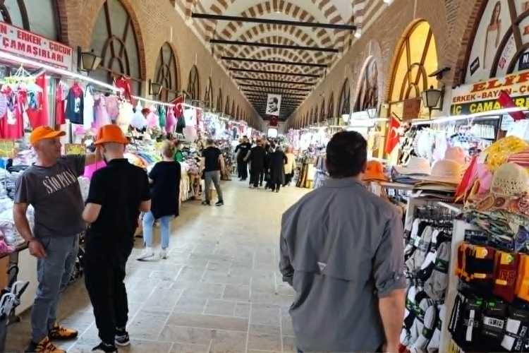 People walking inside Ali Paşa Bazaar in Edirne with textile, clothing, and various traditional shops