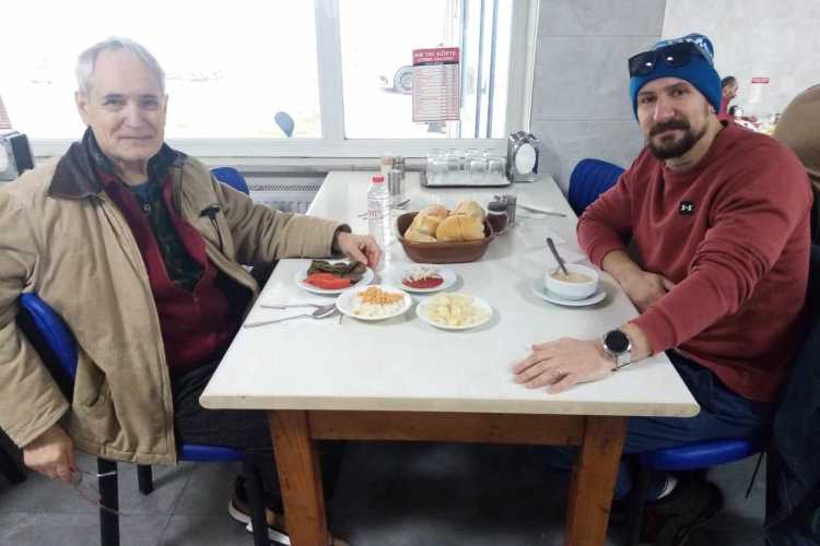 Father and son dining at Birtat Köfte Restaurant in Edirne, with köfte, soup, and rice served on the table.