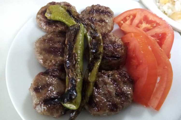 Edirne köftesi served on a plate with garnish, tomatoes and green pepper