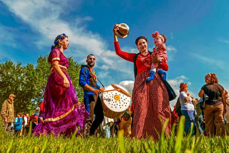 Women in colorful traditional dresses dancing to the rhythm of a davul (Turkish bass drum) at the Kakava Festival in Edirne
