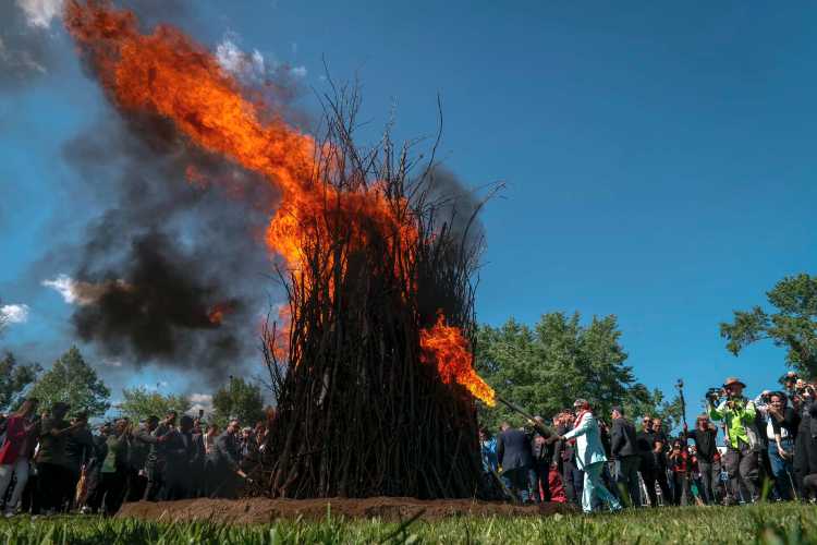 Large crowd gathered around a tall bonfire during the Kakava Festival in Edirne