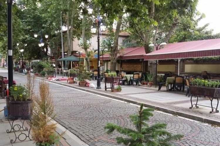 Karaağaç street in Edirne with cobblestone road and cafés lining the right side in a calm neighborhood setting