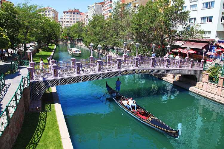Gondola passing under a small bridge over the blue Porsuk River in Eskişehir