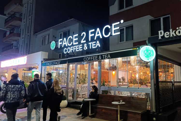 Exterior of Face to Face Coffee & Tea on Bahriye Üçok Street, Edirne, showing young people walking and gathering outside the café