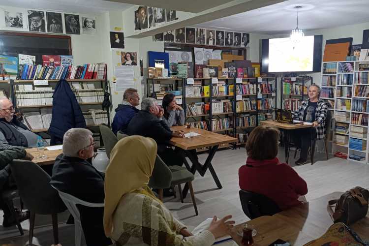Speaker presenting a storytelling session at a small bookshop café in Edirne with audience listening