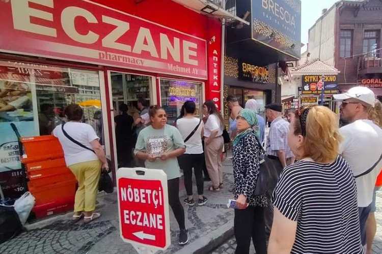 Group of tourists near a pharmacy storefront on an Edirne street