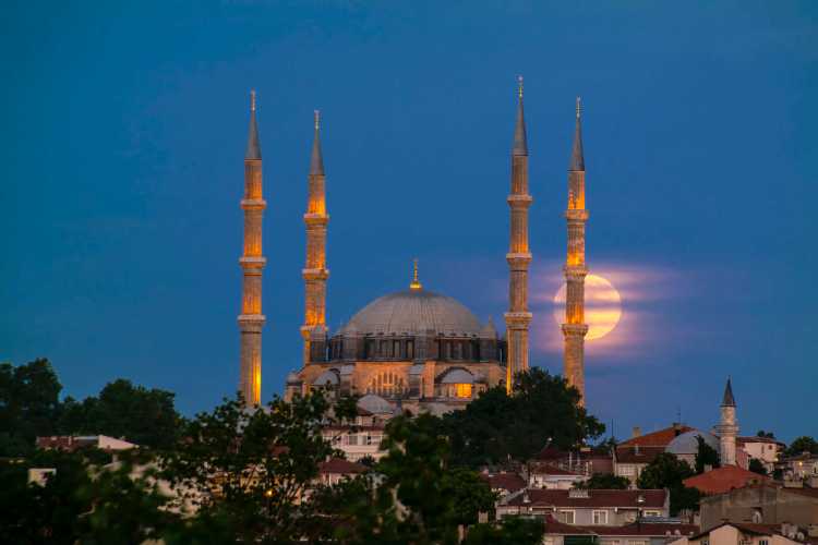 Selimiye Mosque in Edirne at sunset with houses and trees in the foreground