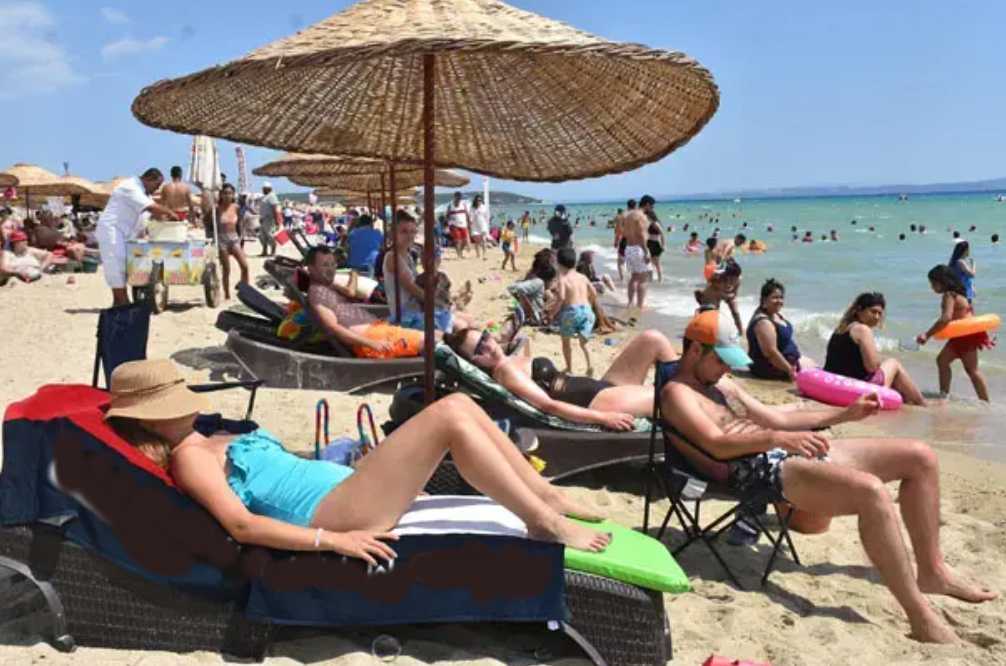 Women relaxing on sunbeds at Erikli Beach along the Saros Gulf coast in Turkey during summer.