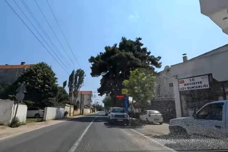 Road passing through Mecidiye village in Edirne, with traditional village-style buildings and houses on both sides.
