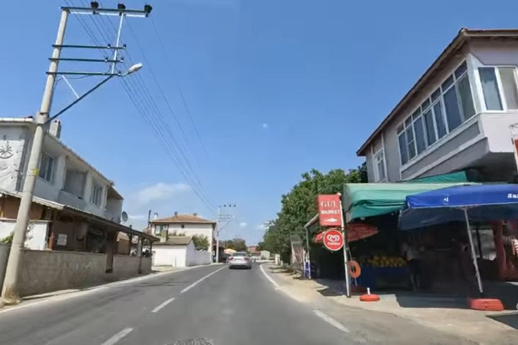 Village road running through Mecidiye in Edirne, lined with similar low-rise houses and simple village-style buildings on both sides.