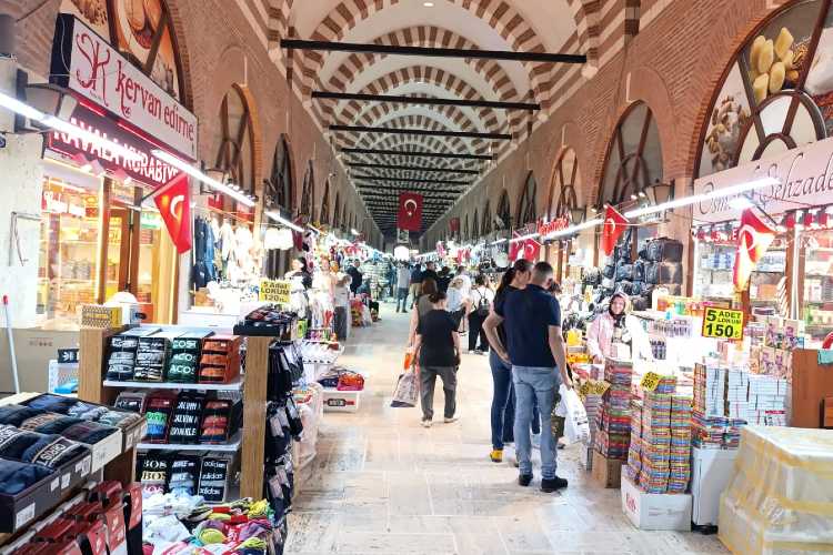 Interior view of Ali Paşa Bazaar in Edirne with shops on both sides of the corridor and people walking and shopping