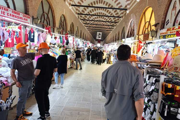 Inside Ali Paşa Bazaar in Edirne with covered corridor, shops on both sides and people walking through the historic market.