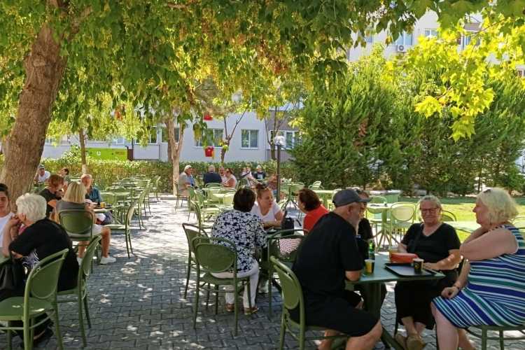 Pensioners sitting at tables in the garden at Vefa Edirne