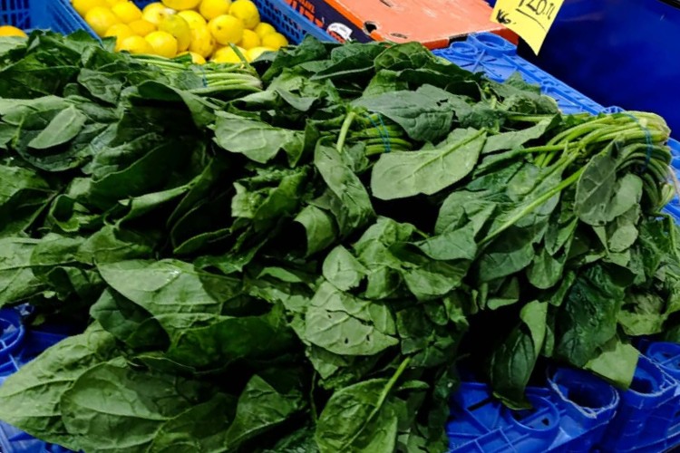 Fresh spinach piled high on a market stall in Edirne, Turkey.
